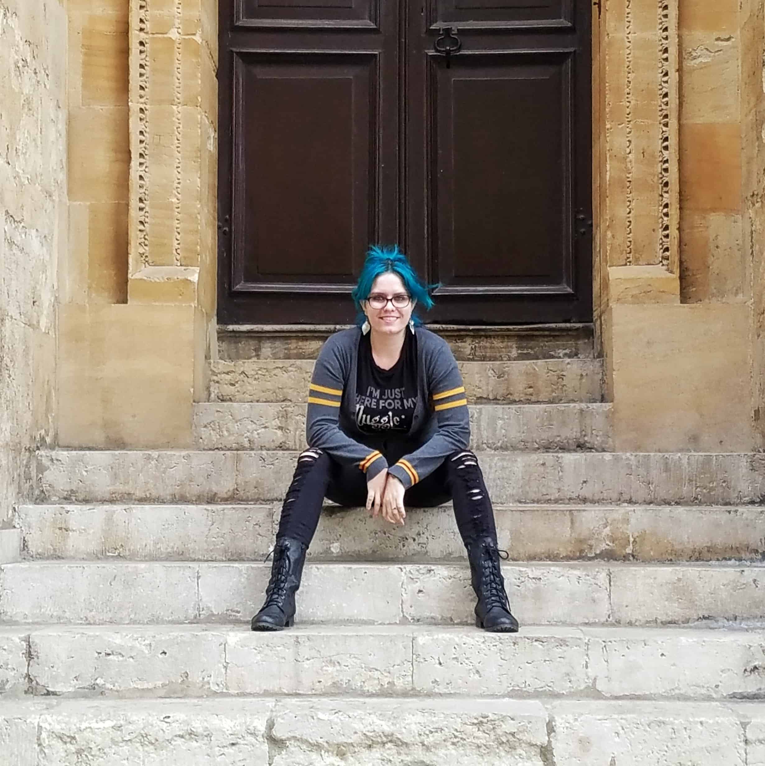 Sckylar sitting on steps outside a building in Oxford, England