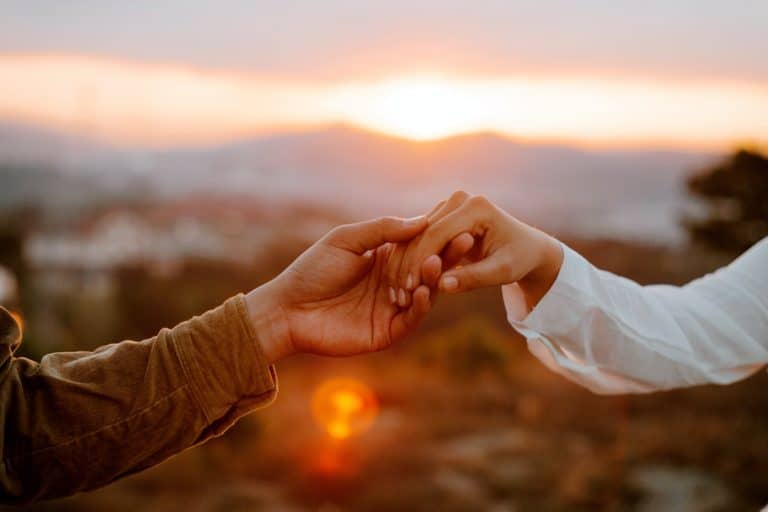 Close up of a couple holding hands outdoors