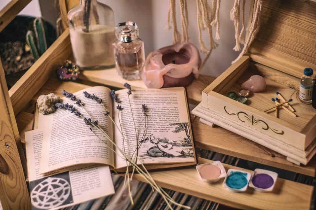 An alter space holds an open book, a candle, and a box with crystals inside, among other miscellaneous items.