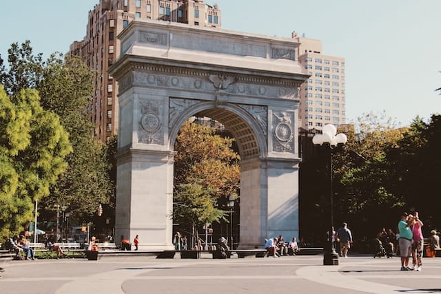 A stone square archway in a park.