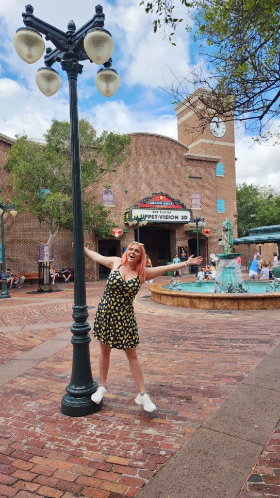 A woman swings from a light post.