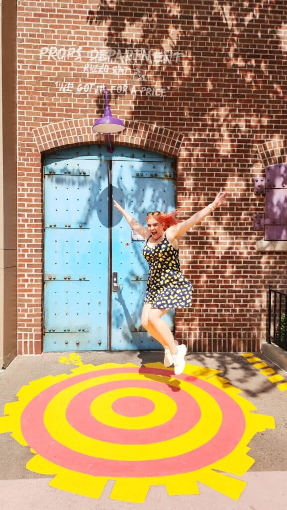 A woman jumps into a target painted on the ground.