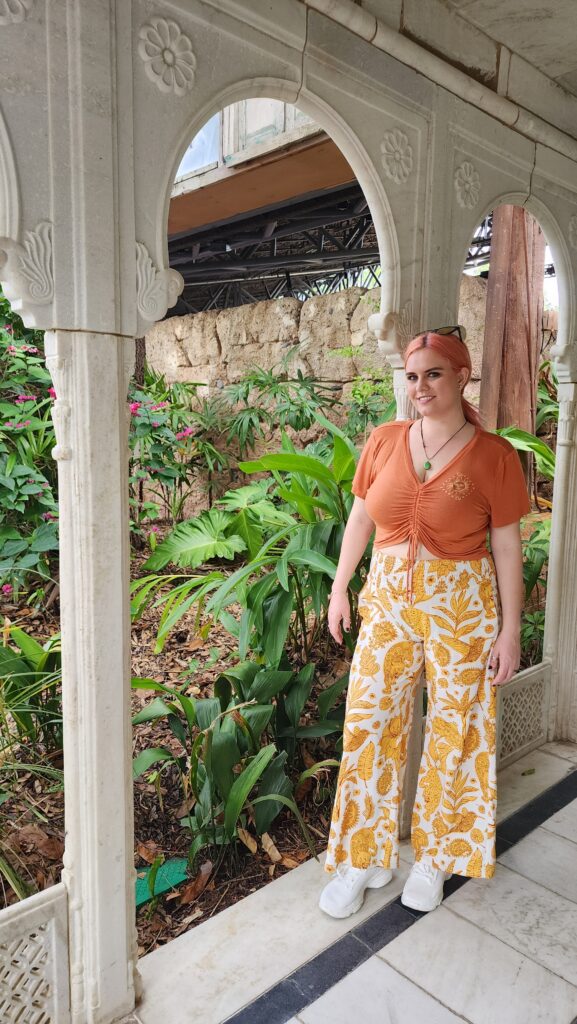 A woman leans against a doorway in a gazebo.