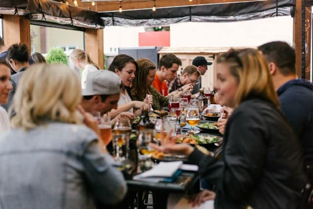 A group of people eat around a table at a restaurant.