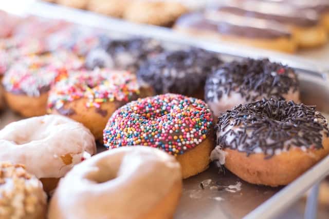 Rows of various donut flavors on display.