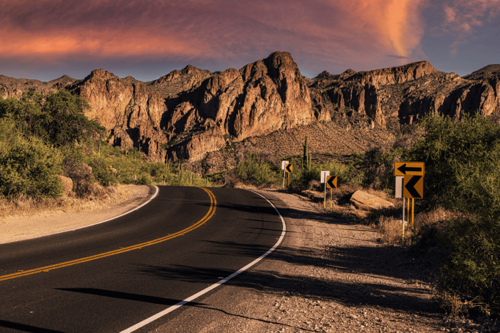 A paved road winds through a mountain landscape in the desert.