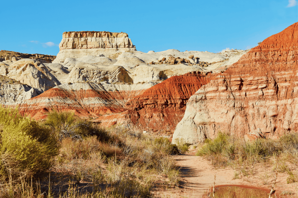 A hiking path cuts through sandy desert  plateaus.