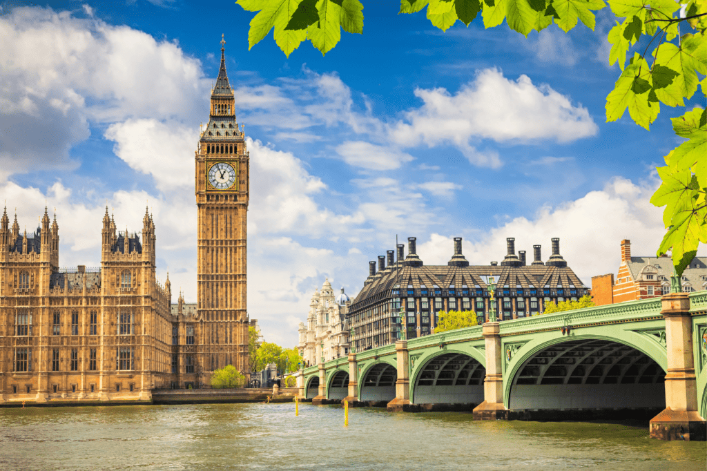 A clock tower stands against a river.