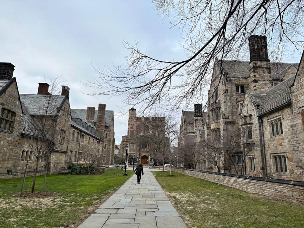 Old brick buildings form a square around a lawn in winter