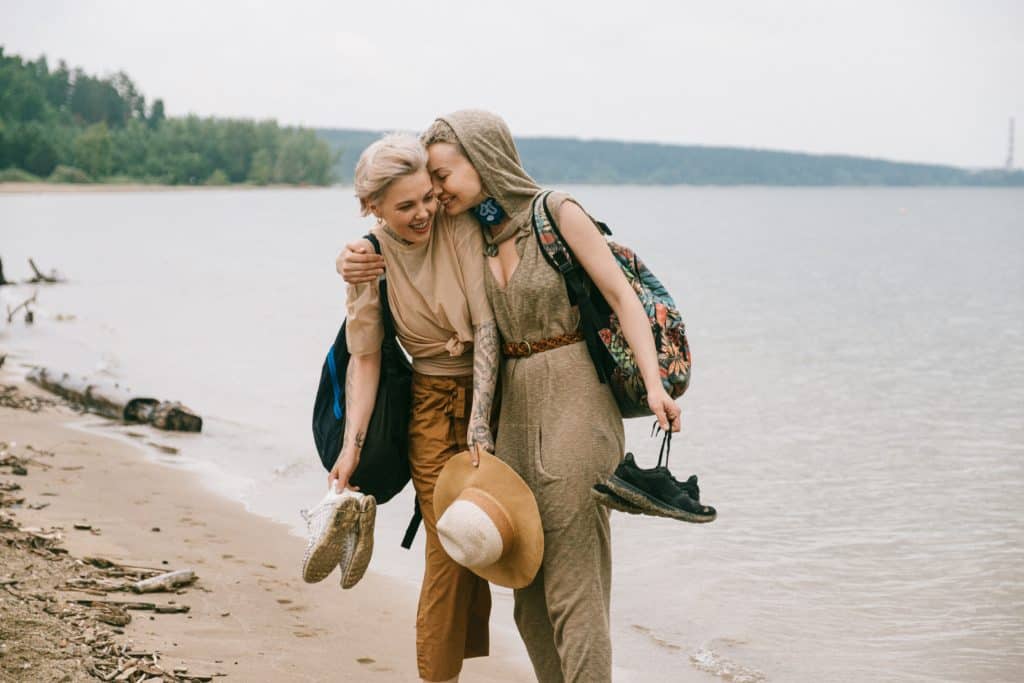 Two women embrace on a beach