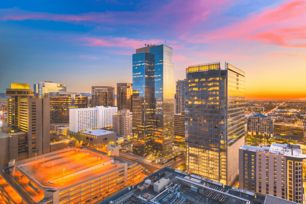The Phoenix skyline reflects a pink sunset off the glass skyscrapers.