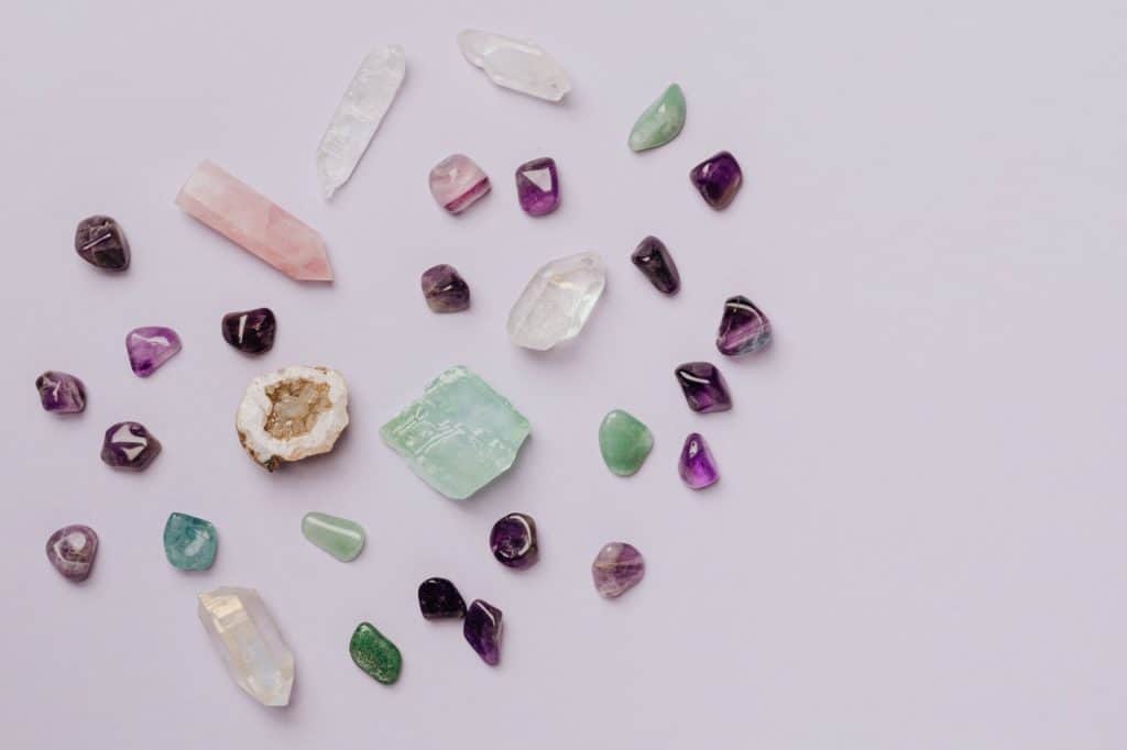 A mixture of different polished stones and cut crystals are spread out to form a heart shape.