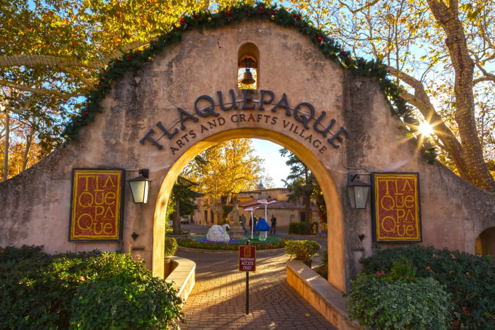 An archway entrance to a shopping center reads, "Tlaquepaque."