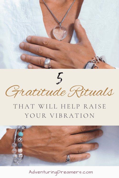 A person wearing many natural stone jewelry pieces lays their hands on their chest. Overlaid text reads, "5 Gratitude Rituals That will Help Raise Your Vibration. Adventuringdreamers.com"