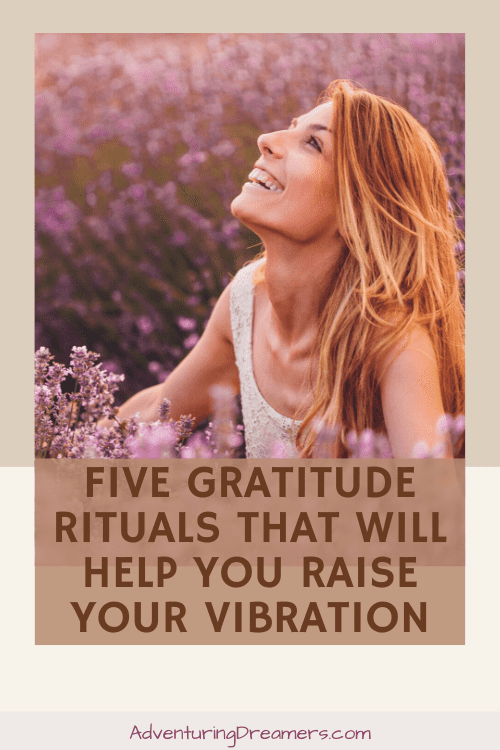 A blonde woman sits in a field of lavender and looks up to the sky with a smile on her face. Overlaid text reads, Five gratitude rituals that will help you raise your vibration. Adventuringdreamers.com"
