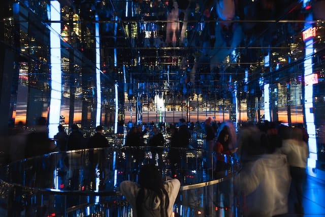 People look at the sunset out of a glass building - Summit One Vanderbilt, an attraction to consider when wondering which New York City Pass is best.