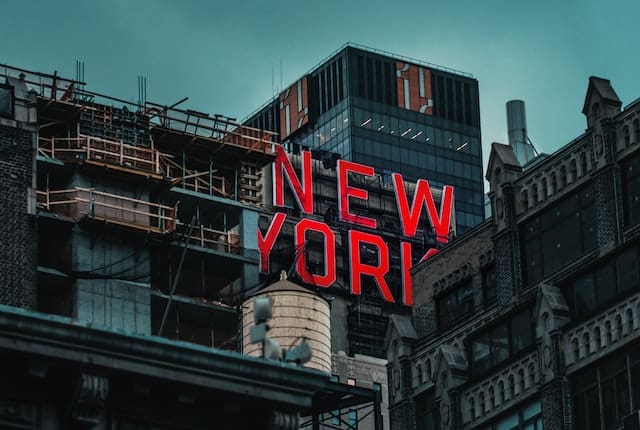 A building with a bright red sign that says New York - which New York pass is best