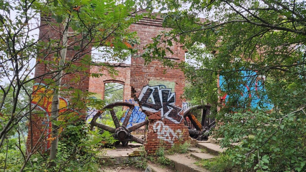 A ruined brick wall covered in graffiti.