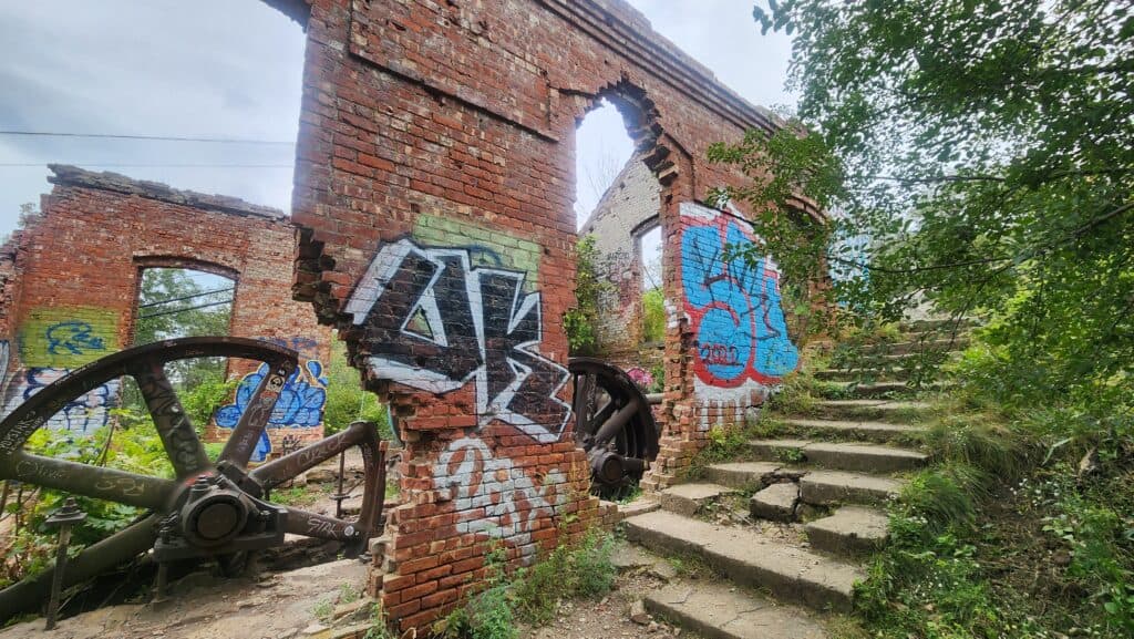 A brick wall ruin covered in graffiti.
