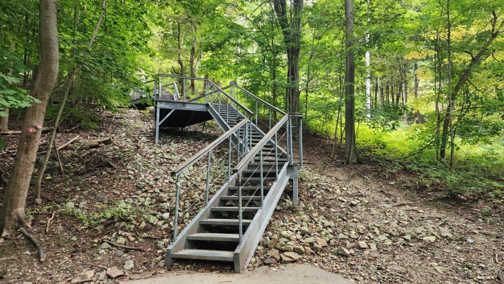 A metal stairwell climbs up the side of a mountain.