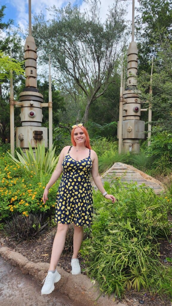 A woman poses in front of two sci-fi statues.