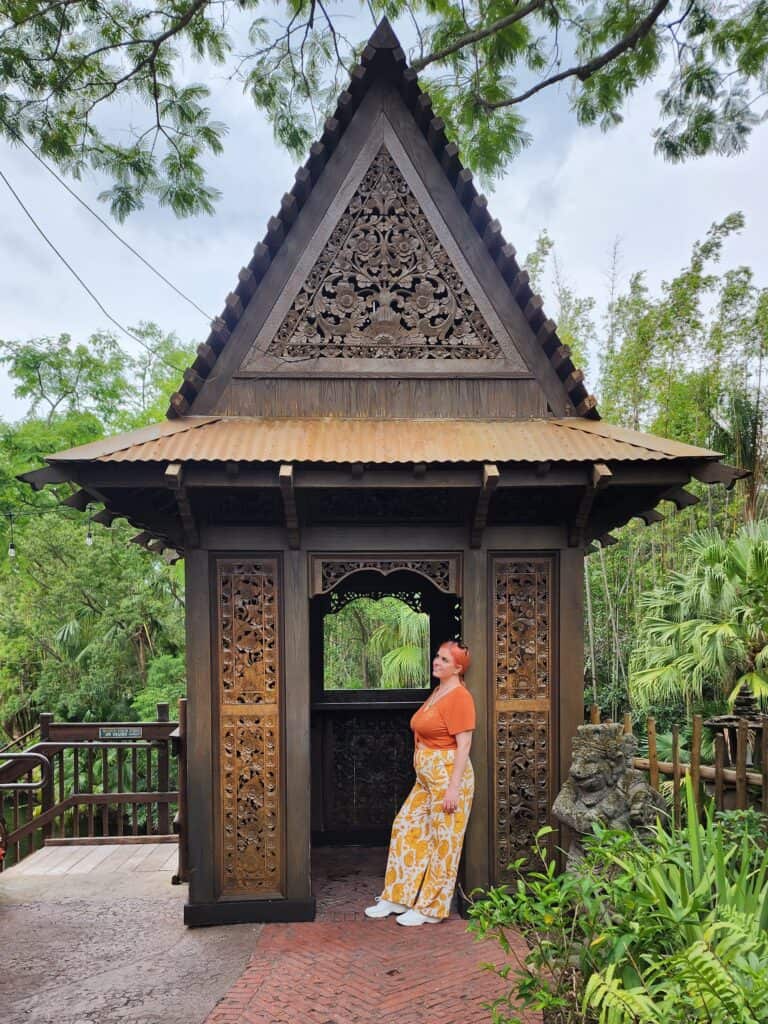 A woman leans against the doorframe of a gazebo.