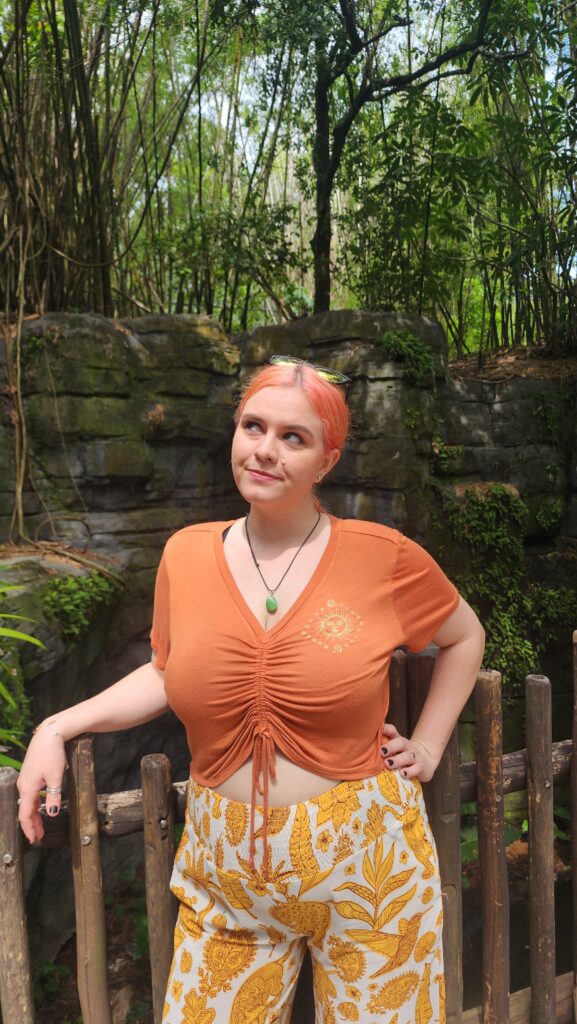 A woman looks up at the sky while in a jungle environment.