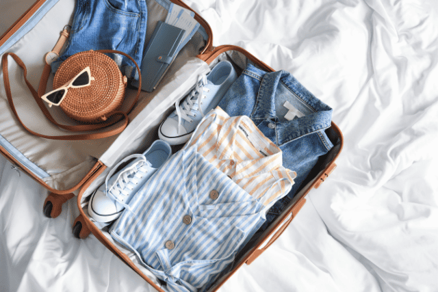 A packed suitcase lays open on a bed.