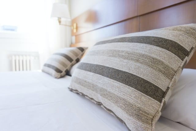 Close up of stripped pillows on a made bed.