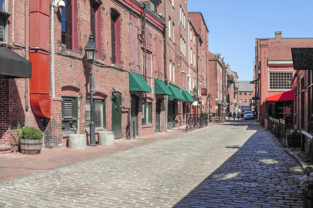 An empty cobblestone street lined with brick buildings.