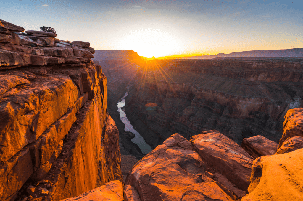 The sun rises over a huge western canyon.