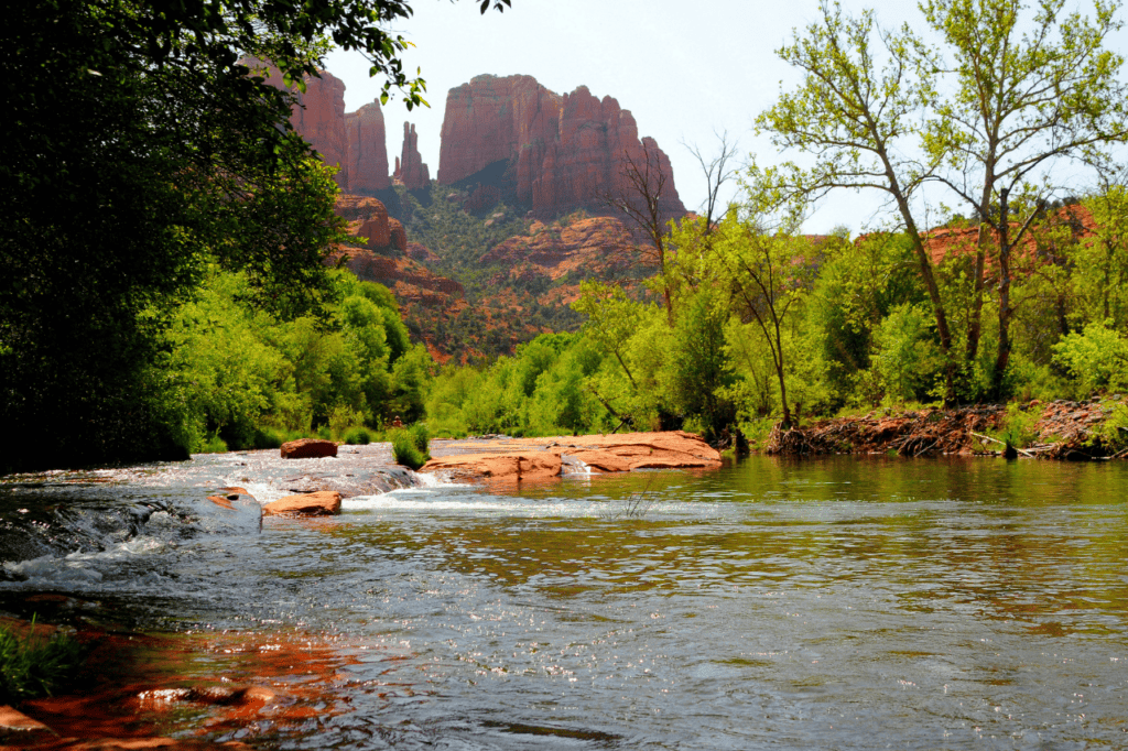 Red rocks peak over the horizon, beyond a river.