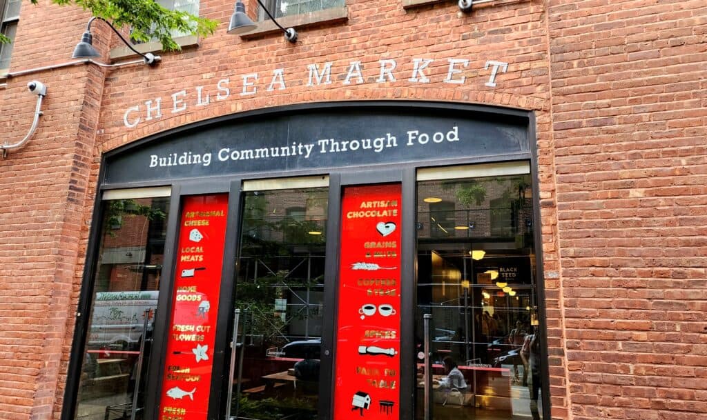 A brick building with a sign above the doorway that says "Chelsea's Market."