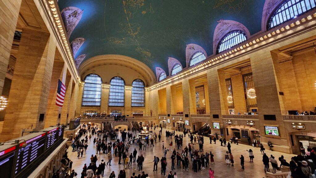 A busy bus terminal with a green dome ceiling.