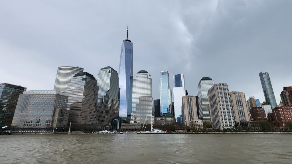 The New York City skyline as viewed from a river on an overcast day.